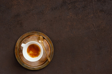 The cup of coffee on the vintage textured brown table