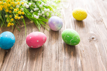 Easter eggs painted in pastel colors on a wooden background