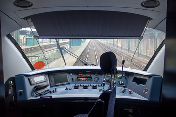 Empty train cabin of driver. Interior of control place of train standing on railway station. Cockpit modern train.