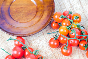 Small Tomato on wood background.Food concept.