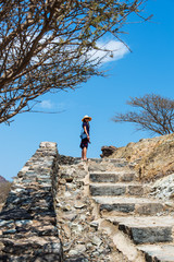 Woman climbing stairs to desert fortress