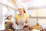 Portrait of adorable little girl and her mother baking together