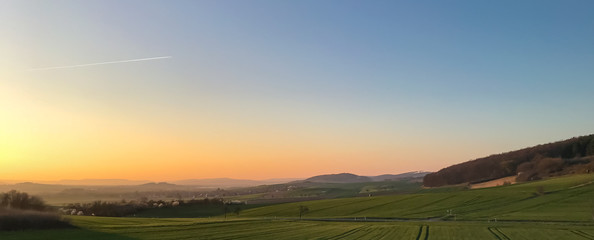Beautiful panorama of countryside in Germany in the evening with setting sun