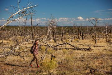 Woman in dead tree forest