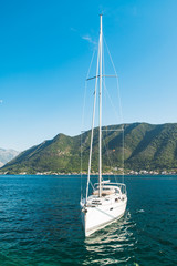 white yacht in sea bay. mountains on background