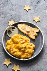 Kids funny breakfast with scrambled eggs, cheese and tortilla