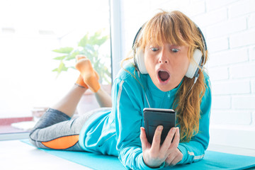 woman in sportswear listening to music with phone and headphones