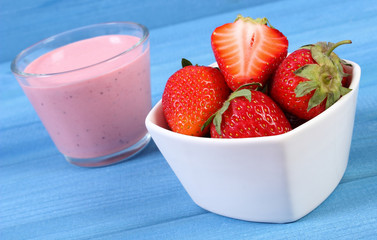 Fresh strawberries and delicious milkshake on boards, healthy dessert