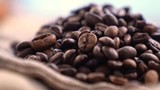 Black Coffee Grains. Black coffee is laid out on a bag spinning on a stand around its axis.