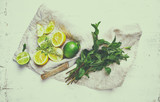 Fresh lemons, lime and herbs for making a lemonade or detox drink. Healthy and natural food ingredients. Flat lay. Copy space