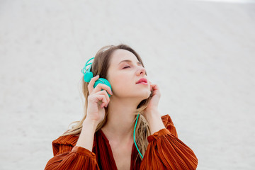 Young woman in burgundy color blouse with headphones