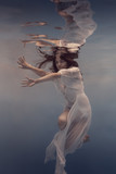 Portrait of a girl in a white dress under water