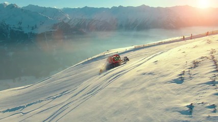 Aerial helicopter shot of calm rural mountain landscape, snow-covered mountain peaks and ski resort landscape at the Austrian Alps on a sunny morning day