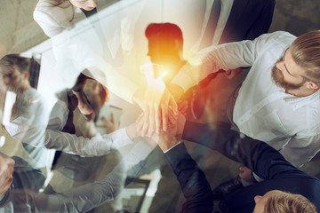 Business people putting their hands together. Concept of startup, integration, teamwork and partnership. Double exposure.