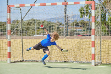 Child playing goalie football at school