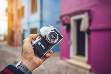 Photographer holding a retro camera in Burano