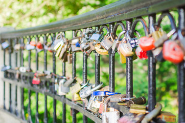 Hinged love locks hanging on a bridge