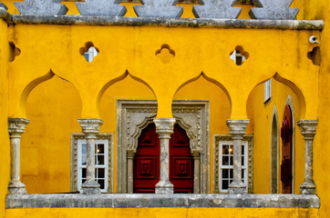 Close up of yellow wall, windows in Pena Palace. Abstract architecture background. Famous landmark in Sintra, Portugal.