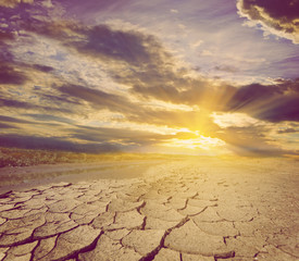 dry cracked land at the sunset, old stylized natural background