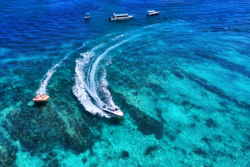 Yachts at the sea in Bali, Indonesia. Aerial view of luxury floating boat on transparent turquoise water at sunny day. Summer seascape from air. Top view from drone. Travel - image