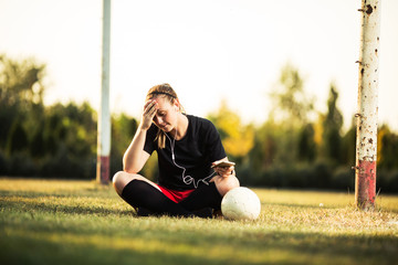 Young female soccer player resting after her training