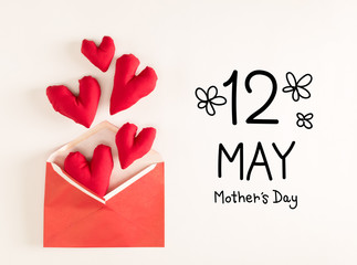 Mother's Day message with red heart cushions coming out of an envelope