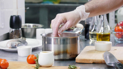 A chef working in the kitchen. Mixing the soup ingredients