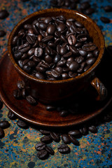 cup with coffee beans on dark background, vertical