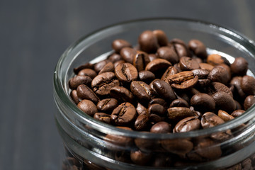jar of coffee beans on a wooden background, concept photo, closeup