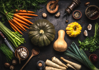 Autumn seasonal food. Colorful various pumpkins and organic farm vegetables on dark kitchen table, top view. Healthy vegetarian cooking. Thanksgiving or Halloween recipes. Seasonal eating