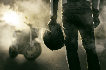 Motorradfahrer und Motorrad stehen im Rauch