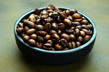 Roasted Coffee beans in a bowl on rusty background
