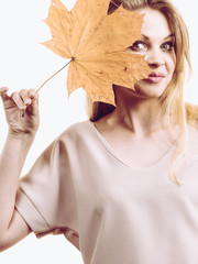 Woman holding maple leaf in hand