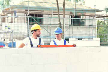 teamwork on the building site - construction workers build a family home