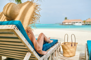 Woman at beach on wooden sun bed loungers