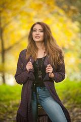 Happy Portrait fashion of a beautiful sensual young Caucasian woman with a long hair , straight jeans and long black boots in autumn park. Autumn, season and people concept.Autumn lifestyle