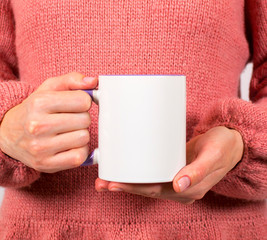 Hands of a young woman holding a Cup of coffee or tea. These mugs are used to apply the logo