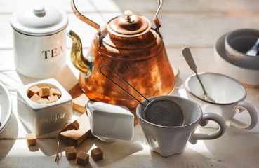 Kitchen still life with copper kettle and ceramic utensils in sunny day