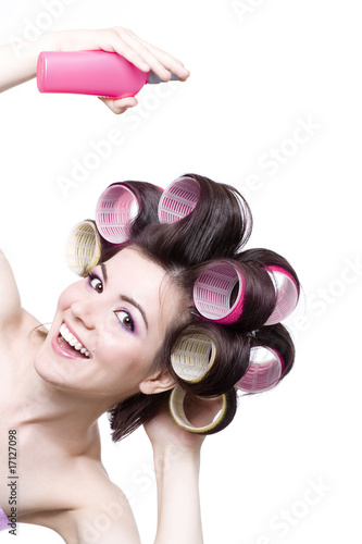  Laughting girl with colorful hair-curlers and hair spray