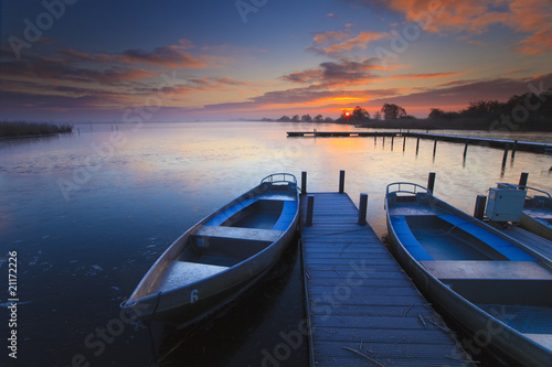 pokojowy-wschod-slonca-z-dramatycznym-niebem-lodziami-i-jetty