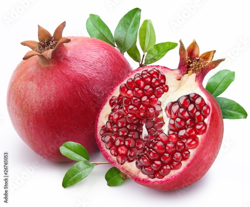 Juicy pomegranate and its half with leaves. © volff