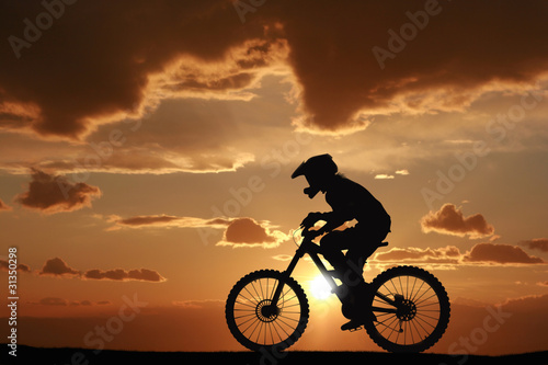 Fototapeta Mountain biker at sunset