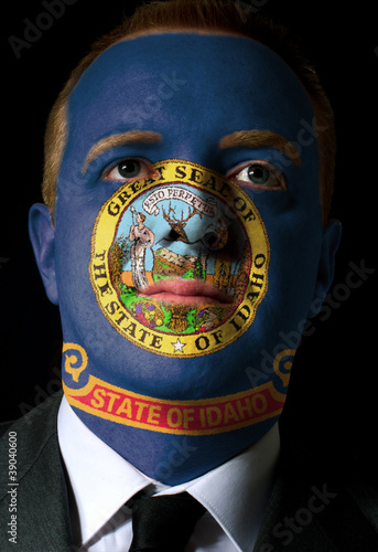 Poster us state of idaho flag painted face of businessman or politician