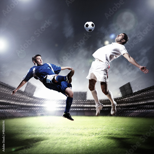 Lacobel two football players striking the ball