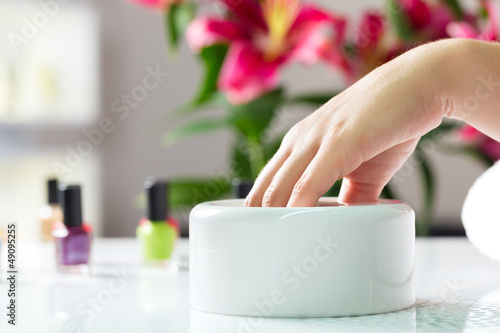  Woman in nail salon receiving manicure