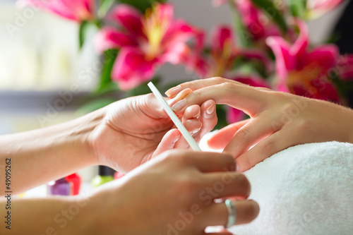 Fototapeta Woman in nail salon receiving manicure