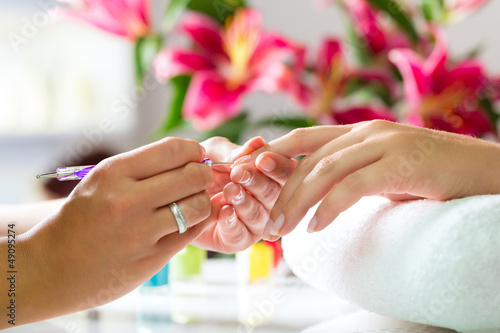  Woman in nail salon receiving manicure