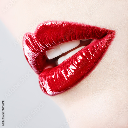 Fototapeta Beautiful female with red shiny lips close up