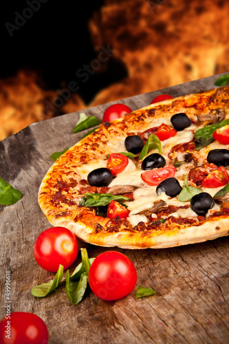 Fototapeta Delicious italian pizza served on wooden table