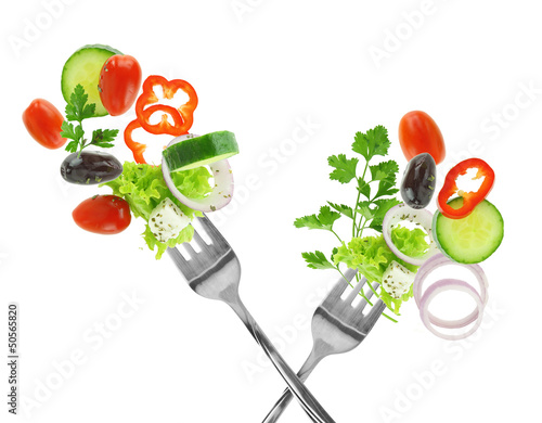 Fototapeta Fresh mixed vegetables and silver forks isolated on white